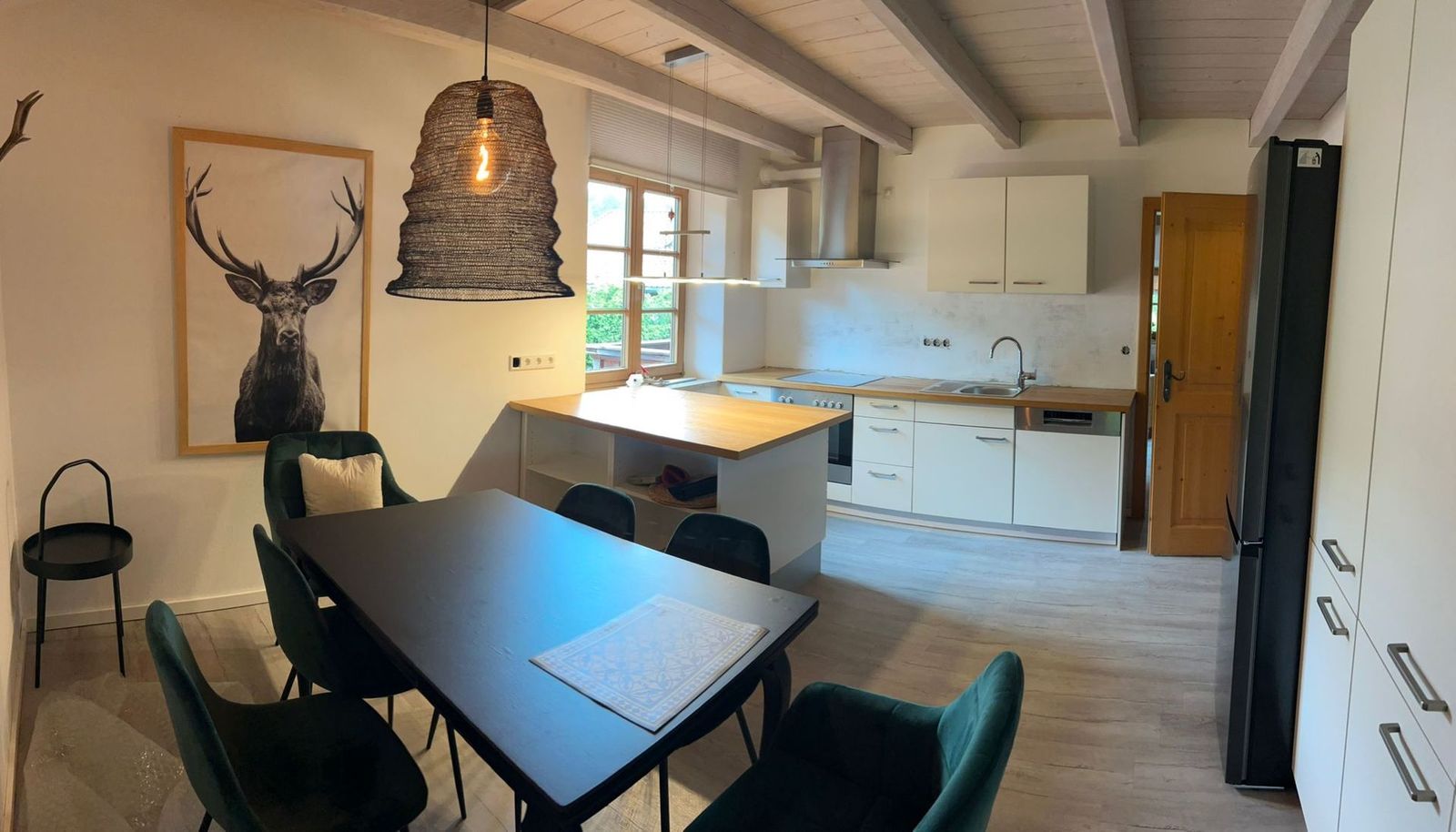 Essbereich der Ferienwohnung Bergblick mit grünen Samtstühlen und Blick in den Garten